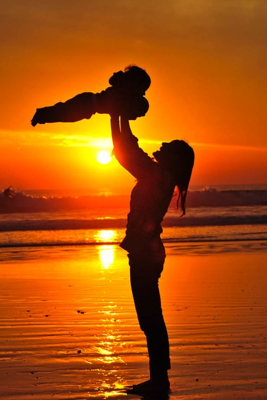 Maman avec un enfant au couché de soleil